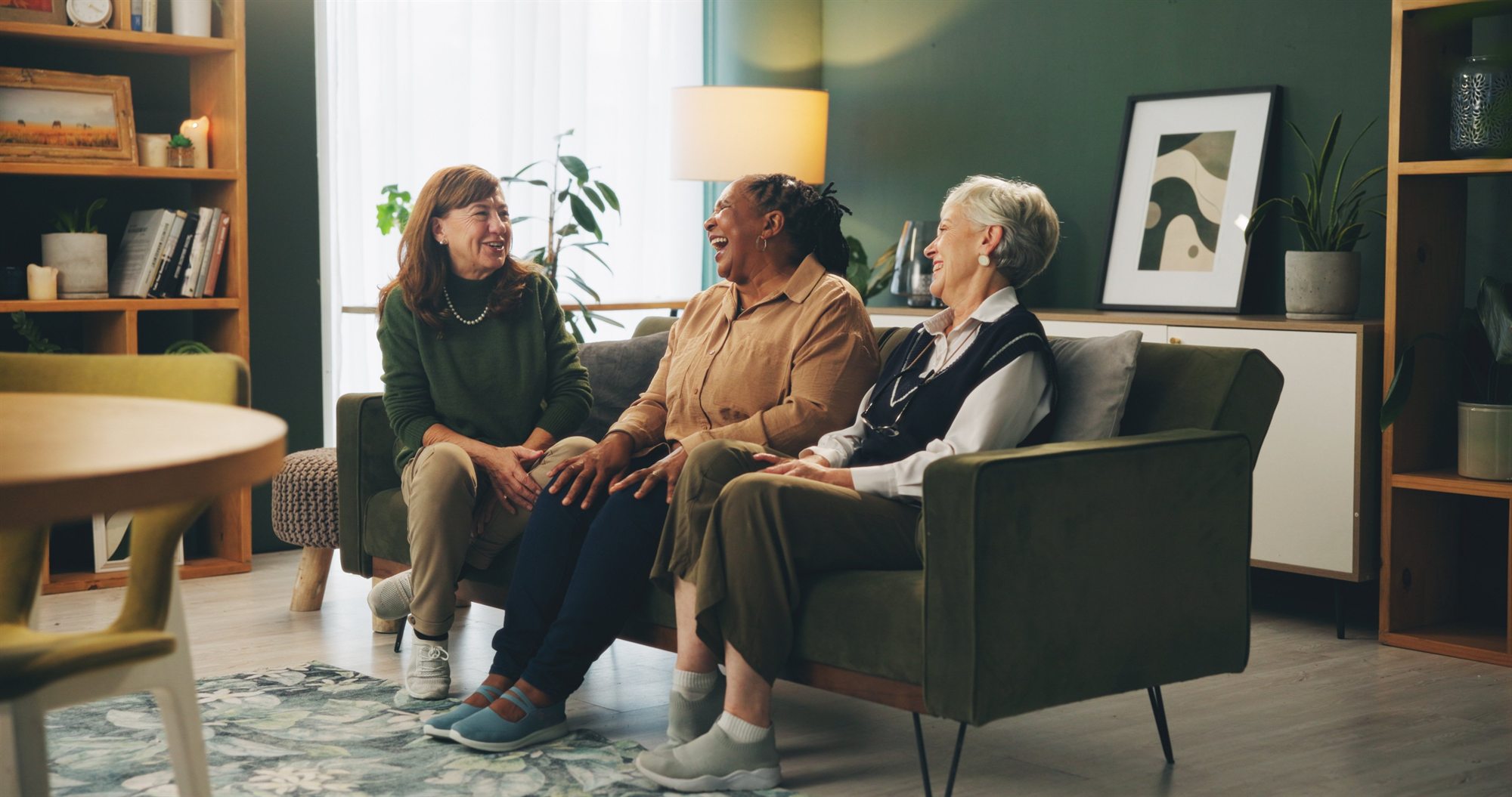 Women smiling together in a comfortable assisted living community space